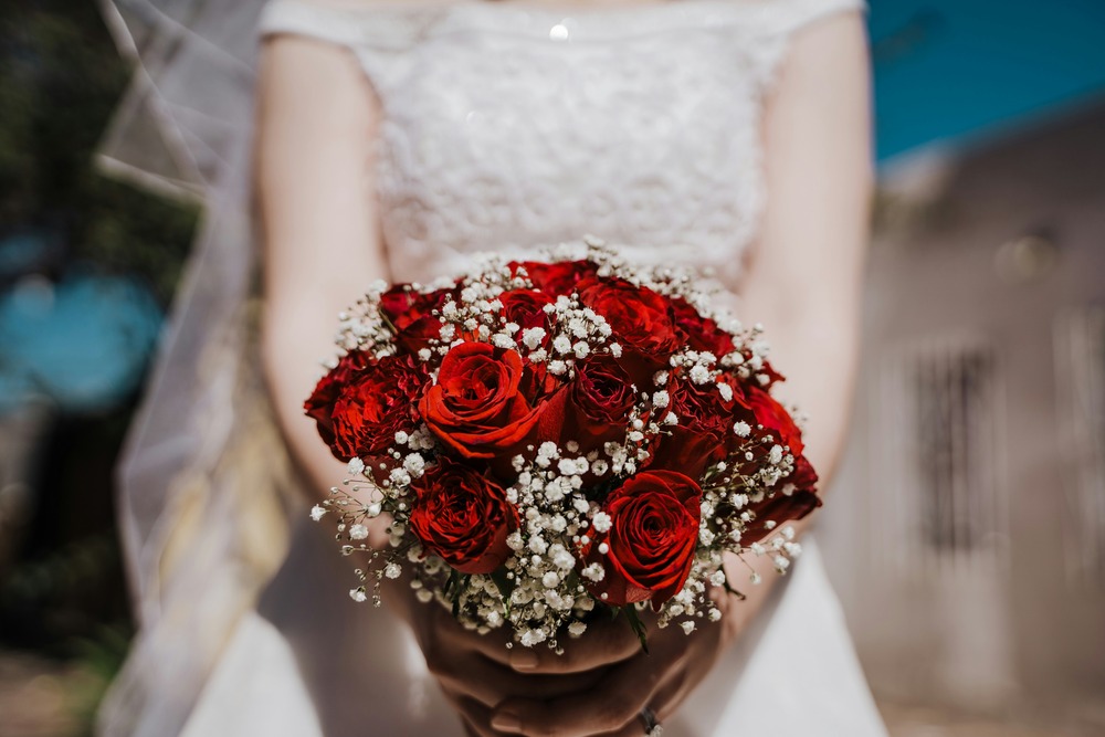 bouquet de roses rouges tenu par une mariée